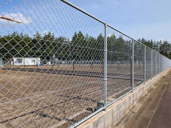 栽培予定の隔離圃場。奥に見える白い建物に器具や収穫後の種子等を格納している。